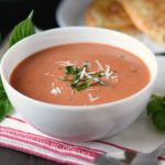 instant pot creamy tomato basil soup with parmesan and basil in a white bowl