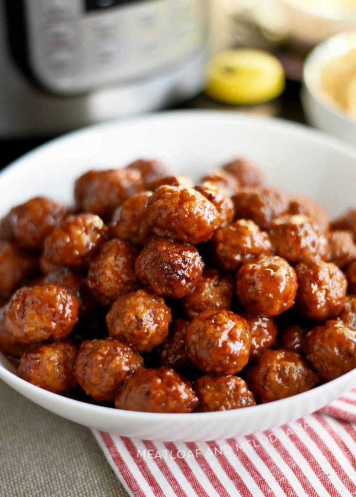 instant pot grape jelly meatballs with sweet chili sauce in white serving bowl
