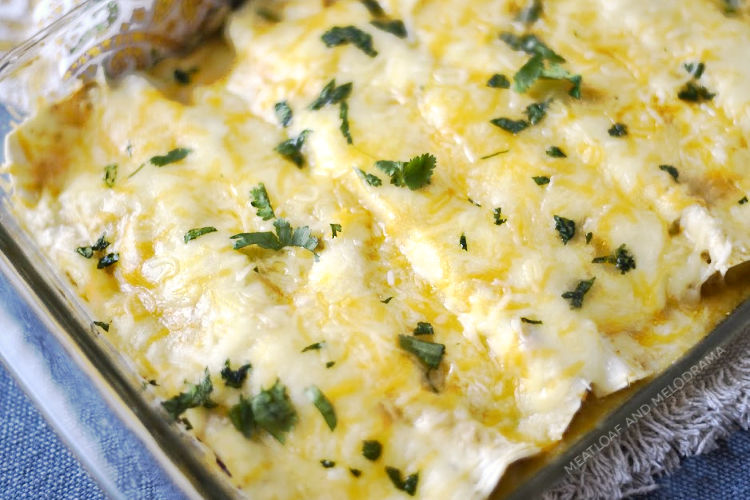 instant pot creamy chicken enchiladas in baking dish with shredded cheese and cilantro