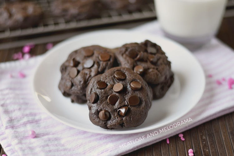 double chocolate chip cookies on a white plate with a glass of milk
