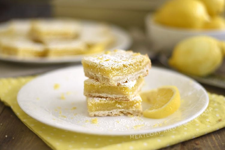 easy lemon bars with shortbread crust and powdered sugar topping on white plate