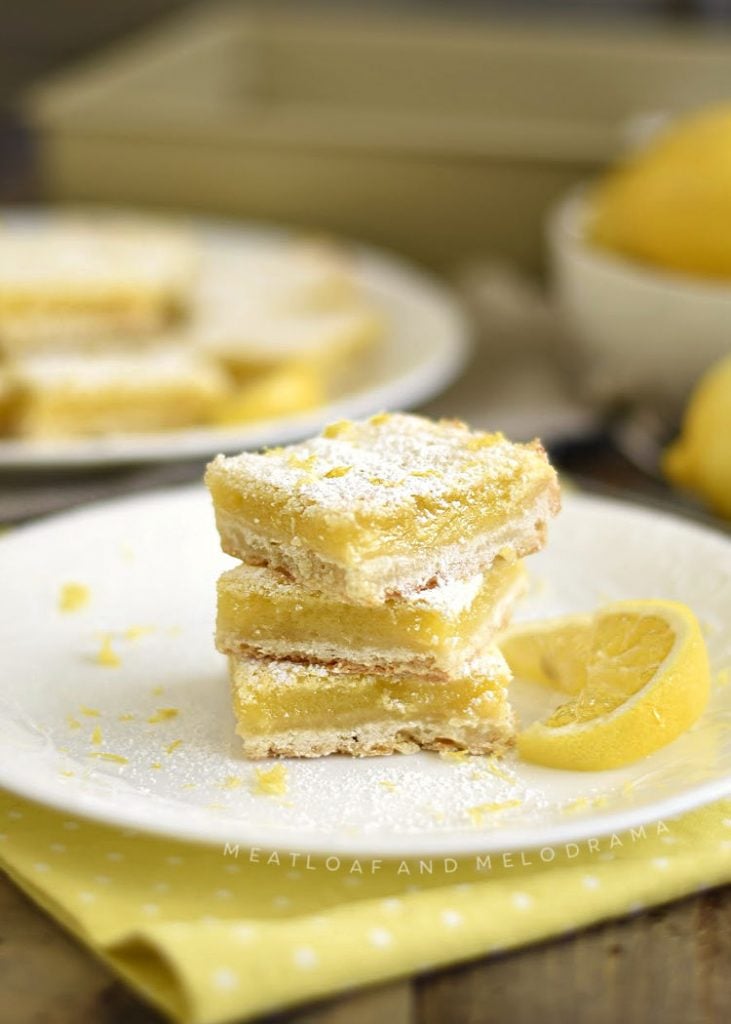 easy lemon bars with powdered sugar stacked on white plate