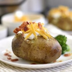 instant pot baked potatoes with sour cream cheddar cheese and bacon on a plate