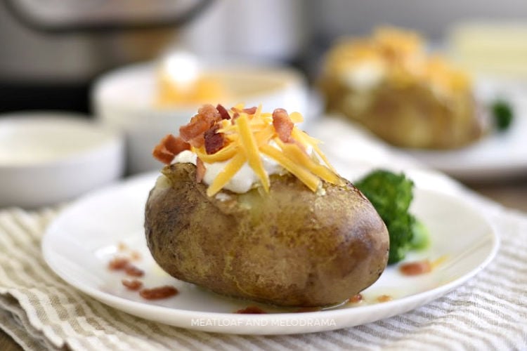 instant pot baked potatoes with sour cream cheddar cheese and bacon on a plate