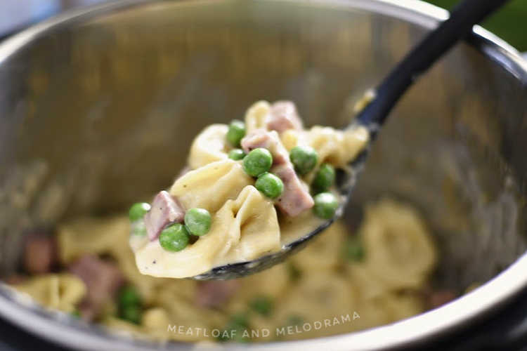 instant pot ham and cheese tortellini with peas in a creamy sauce on a spoon