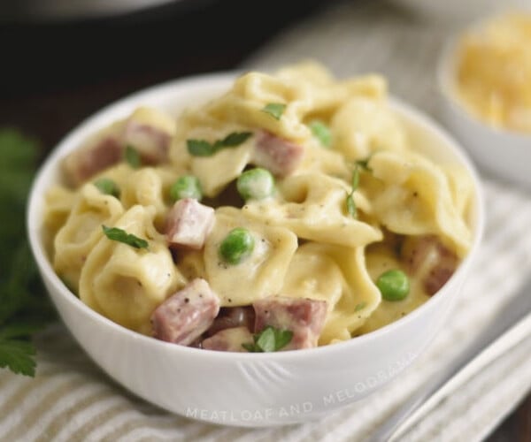 instant pot ham and cheese tortellini with peas in a white bowl