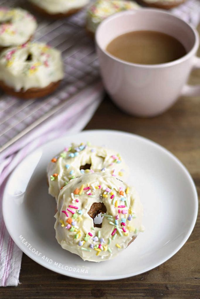carrot cake donuts with cream cheese frosting on white plate