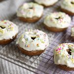 baked carrot cake donuts with cream cheese frosting on baking rack