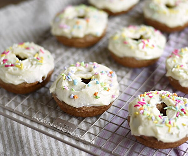 baked carrot cake donuts with cream cheese frosting on baking rack