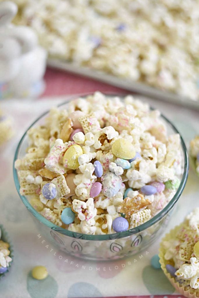 bunny bait snack mix with popcorn chex mix mini marshmallows and easter candy in a glass bowl