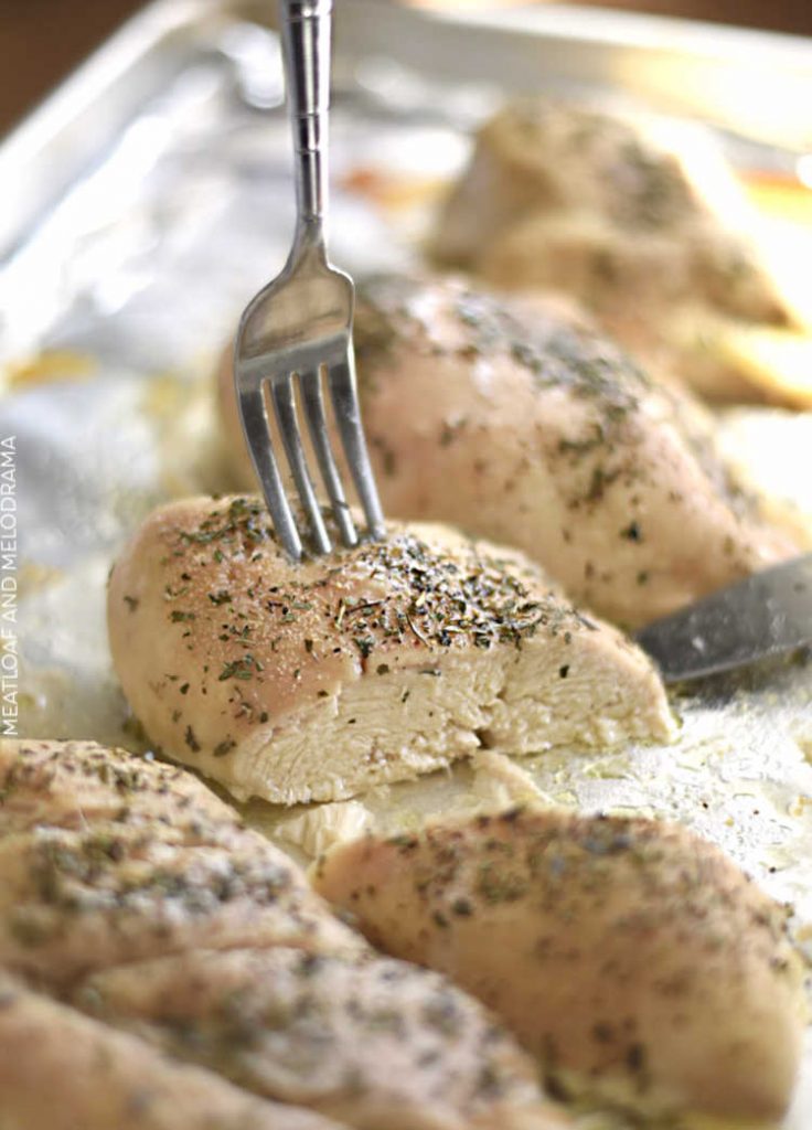 juicy baked chicken breasts on tray cut open