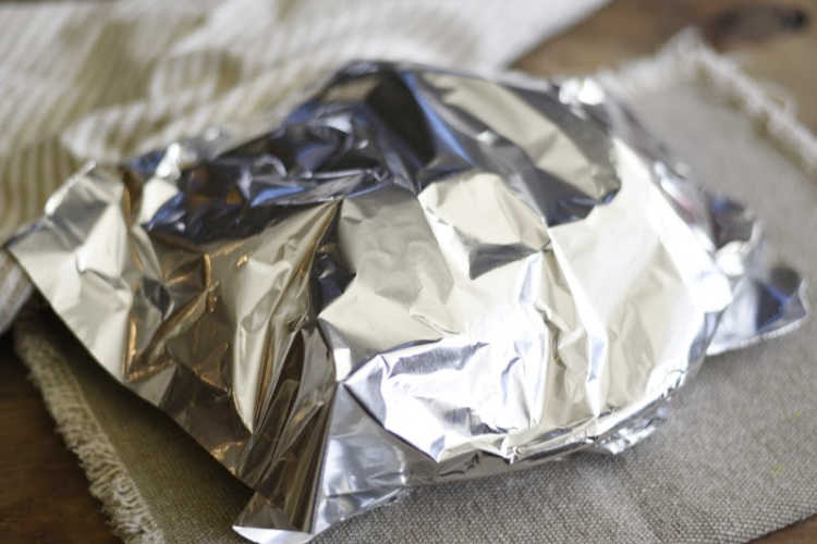  microwaves potatoes on a plate covered with foil