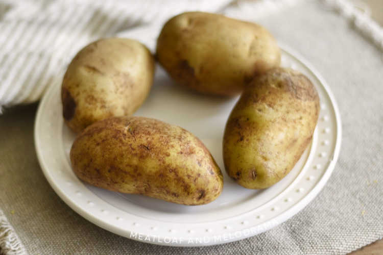 scrubbed russet potatoes on white plate