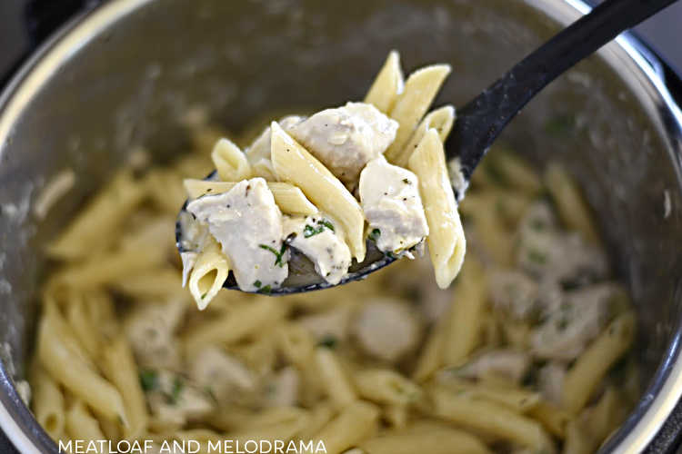 creamy lemon chicken and penne pasta on spoon in the instant pot