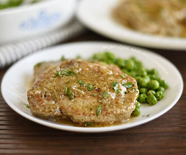 instant pot boneless pork chops on a plate with gravy and peas