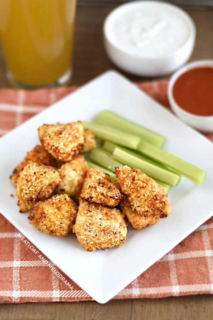 panko coated buffalo chicken bites on white plate with celery