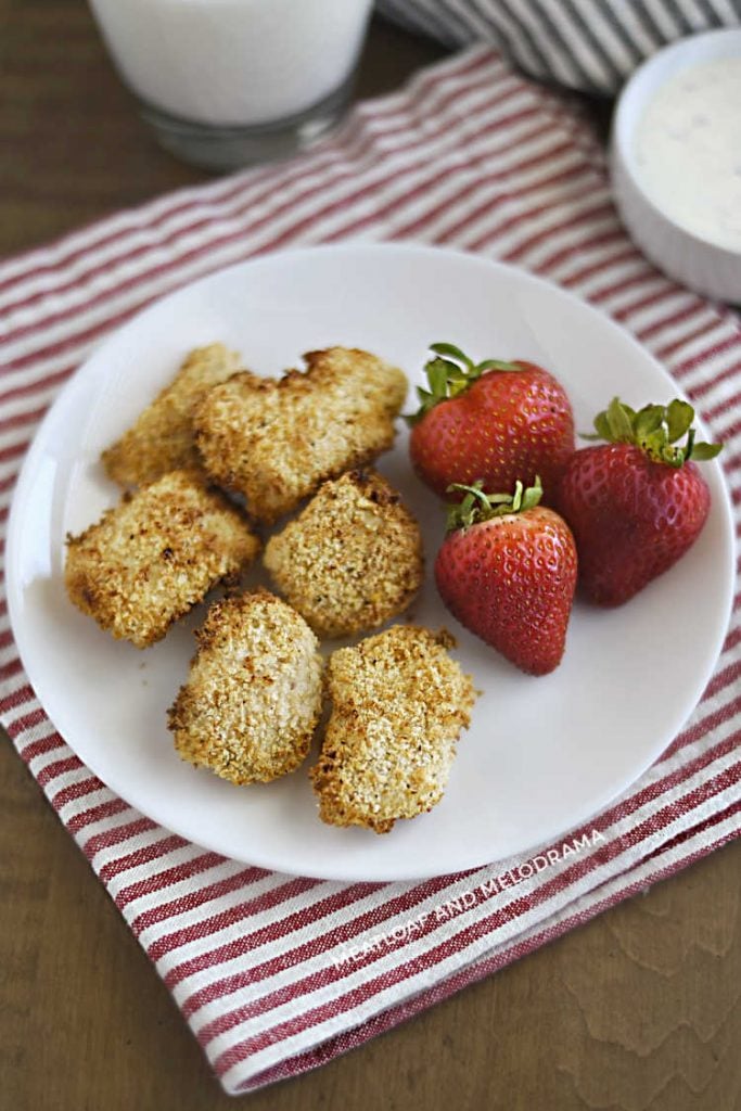 panko crusted chicken nuggets on a plate with strawberries
