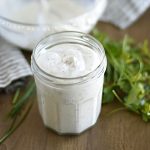 homemade ranch dressing in a glass jar with parsley and chives