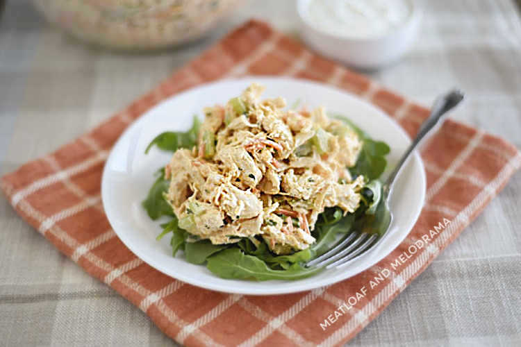 Instant Pot buffalo chicken salad over arugula on a white plate