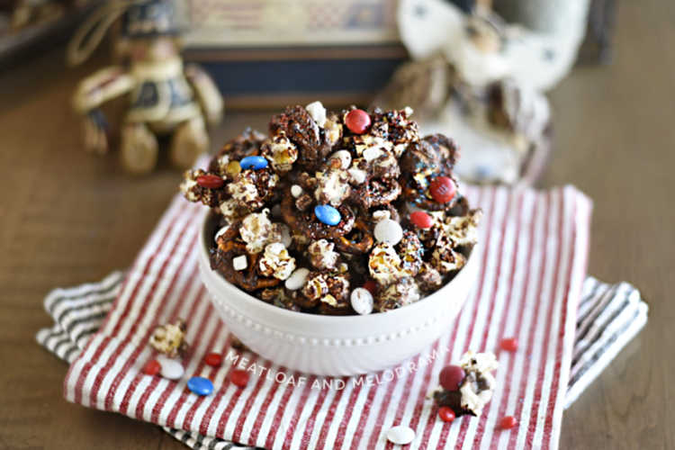 patriotic pretzel popcorn snack mix with red white and blue candies in white bowl