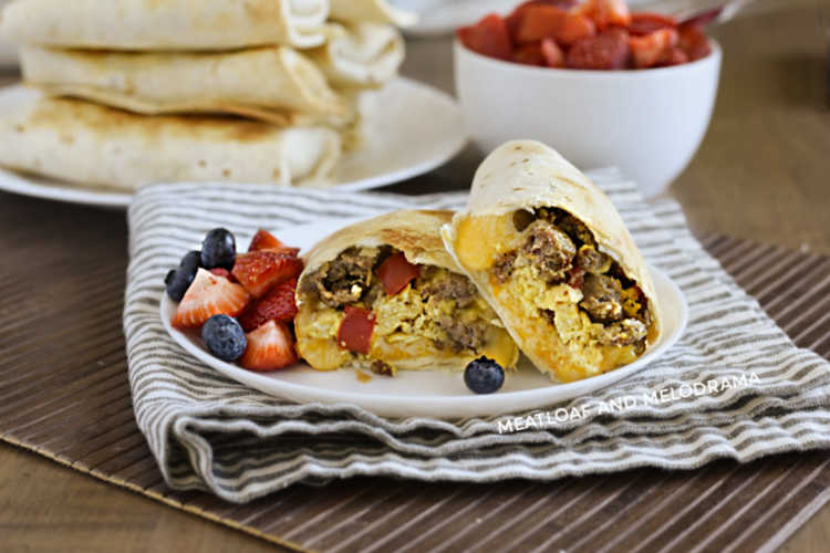 breakfast burritos made in the air fryer on a plate with strawberries and blueberries