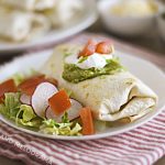 air fryer chicken chimichanga with sour cream and guacamole on a white plate