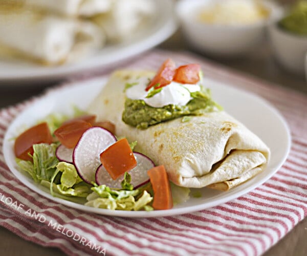 air fryer chicken chimichanga with sour cream and guacamole on a white plate