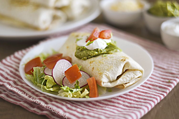 air fryer chicken chimichanga with sour cream and guacamole on a white plate