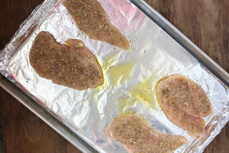 thin sliced chicken breasts on baking sheet