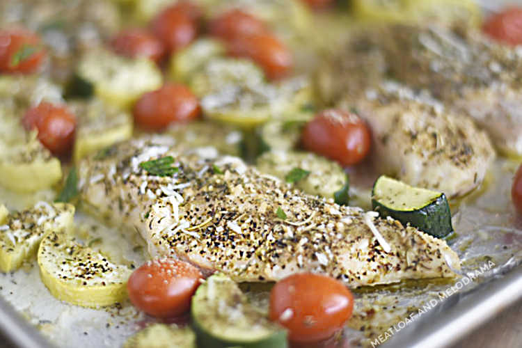 baked chicken with zucchini, yellow squash and grape tomatoes on a sheet pan