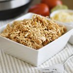 shredded instant pot salsa chicken in a white serving dish