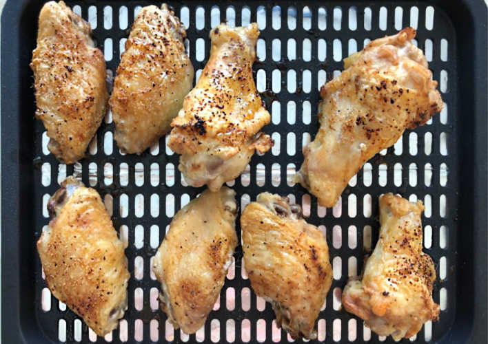 crispy seasoned air fried chicken wings on cooking rack