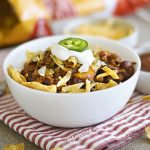 bowl of instant pot frito chili pie with corn chips, cheese and sour cream