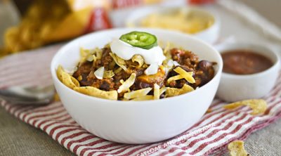 bowl of instant pot frito chili pie with corn chips, cheese and sour cream