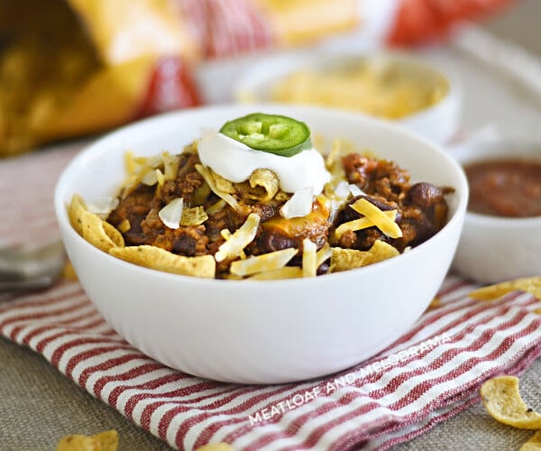 bowl of instant pot frito chili pie with corn chips, cheese and sour cream