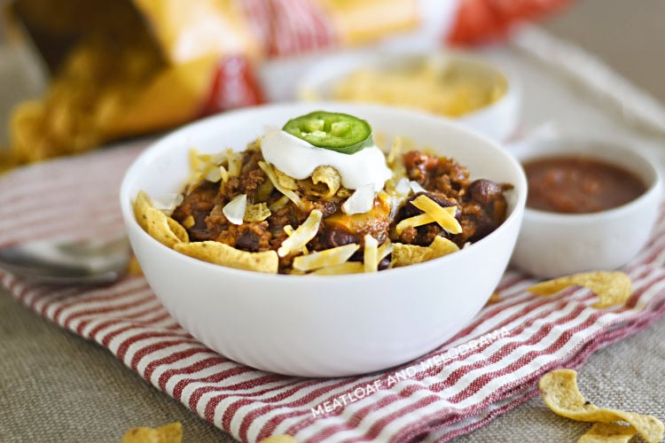 bowl of instant pot frito chili pie with corn chips, cheese and sour cream 