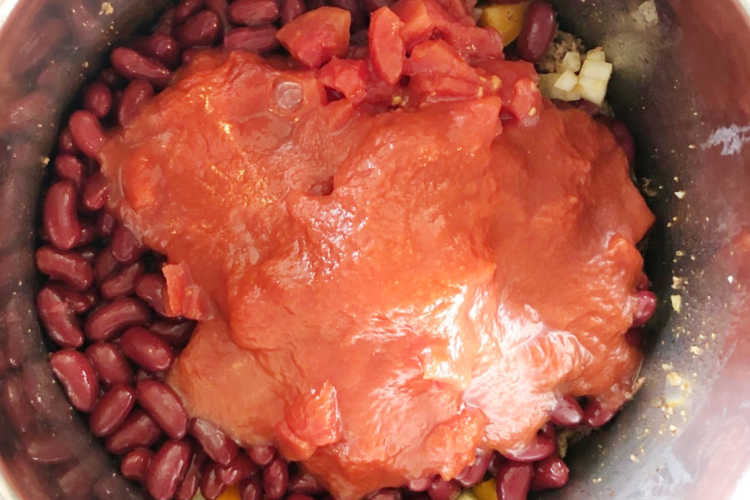 layer chili ingredients and tomato sauce in the pressure cooker