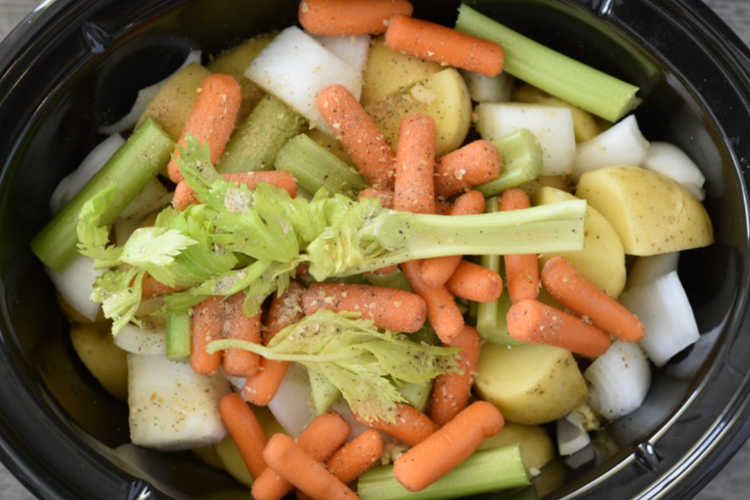 layer potatoes, baby carrots and celery stalks over chuck roast in crock-pot
