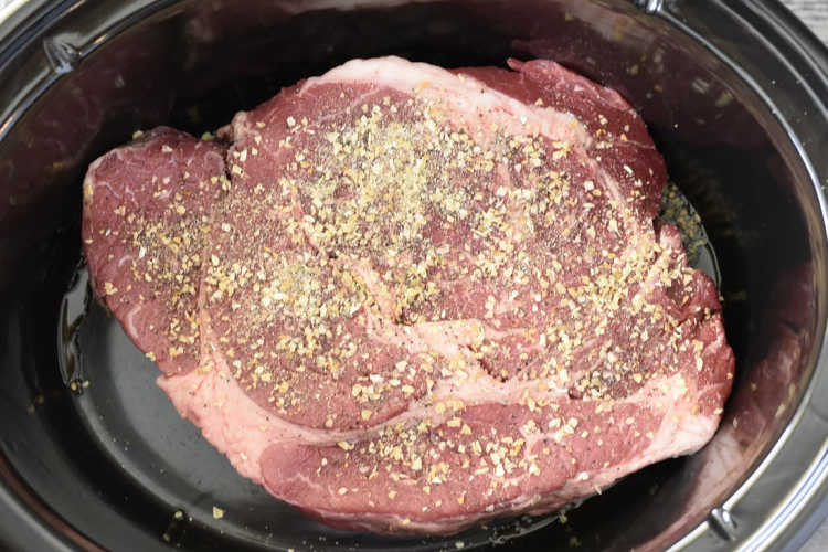 beef chuck roast with sea salt, garlic powder, pepper and minced onions in the crock pot