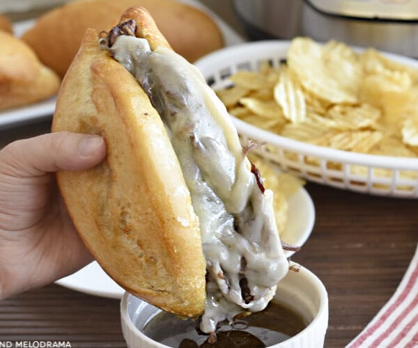 french dip sandwich made in the instant pot with melted provolone cheese dipped in homemade beef gravy
