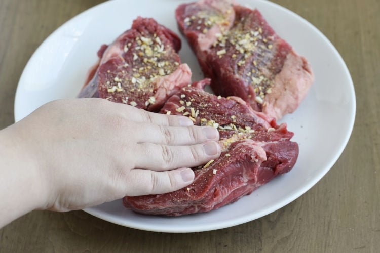 rub seasoning into cut chuck roast for french dip sandwiches