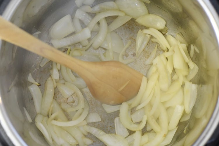 saute cut onions in the instant pot pressure cooker using wooden spoon