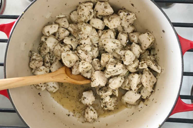 cooked cubed chicken with Italian seasoning in a dutch oven
