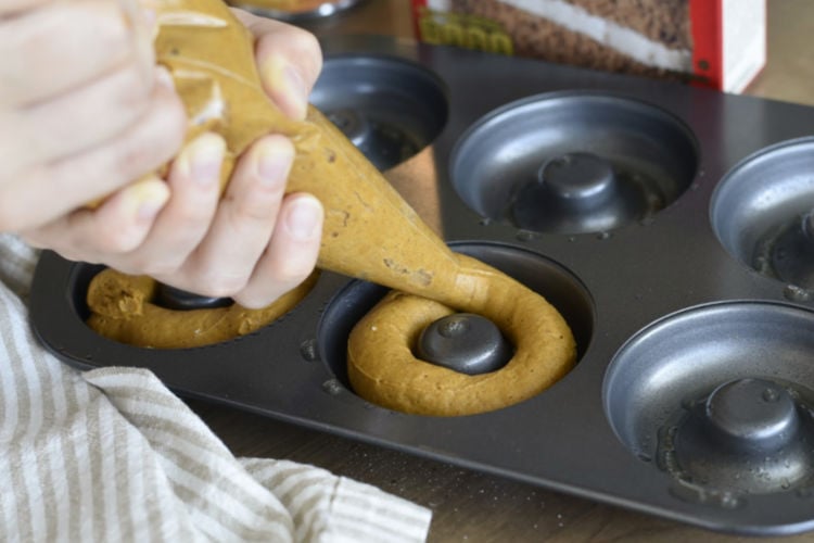 pipe cake mix into donut pan with piping bag