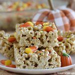 pumpkin spice cheerios treats with candy corn on a white plate with pumpkins