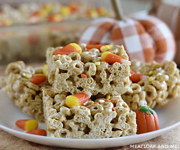 pumpkin spice cheerios treats with candy corn on a white plate with pumpkins