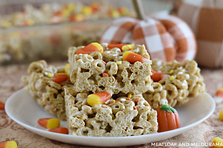 pumpkin spice cheerios treats with candy corn on a white plate with pumpkins