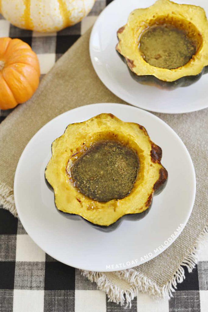 baked acorn squash filled with maple syrup and brown sugar on a plate