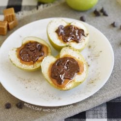 baked chocolate caramel apple halves topped with sea salt on a plate