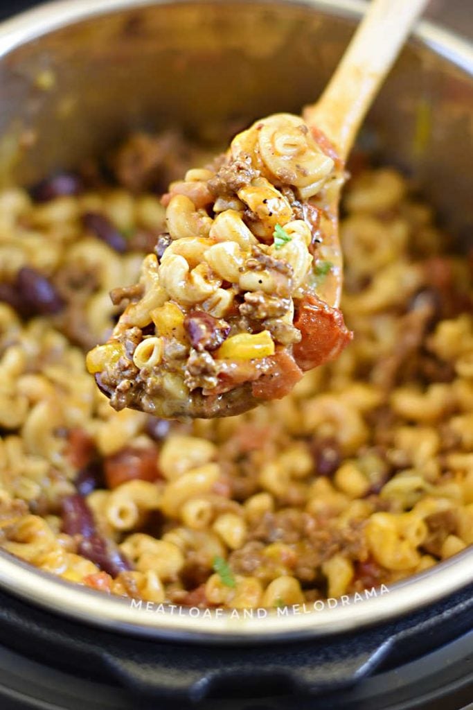 chili mac and cheese on a wooden spoon in the instant pot